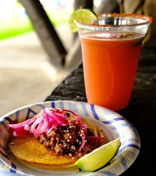 Teller mit Tacos und Orangengetränk mit Limette' title='Tacos